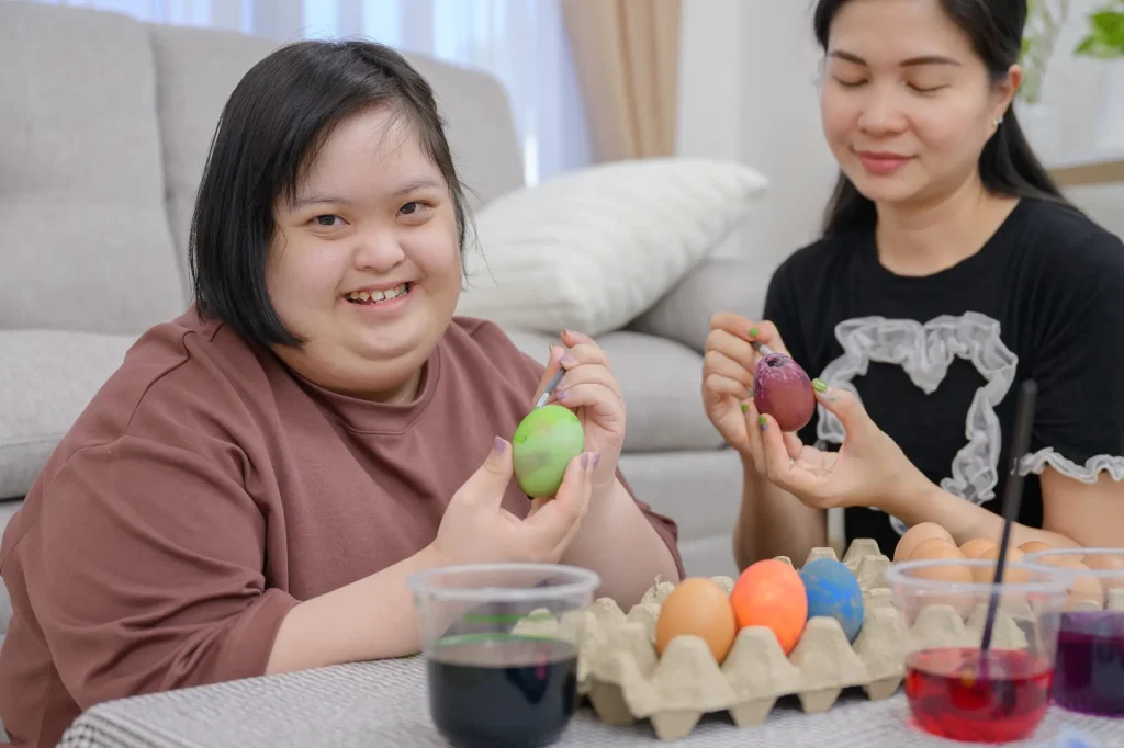 Disabled woman and carer doing arts and crafts