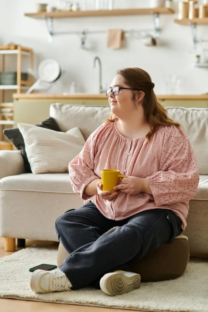 young disabled woman sitting on a cushion drinking tea